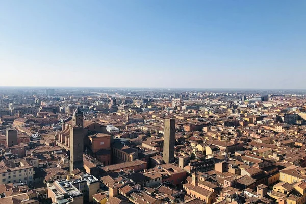 Vista panorámica de Bologna con sus características torres medievales y tejados rojos bajo la luz del atardecer