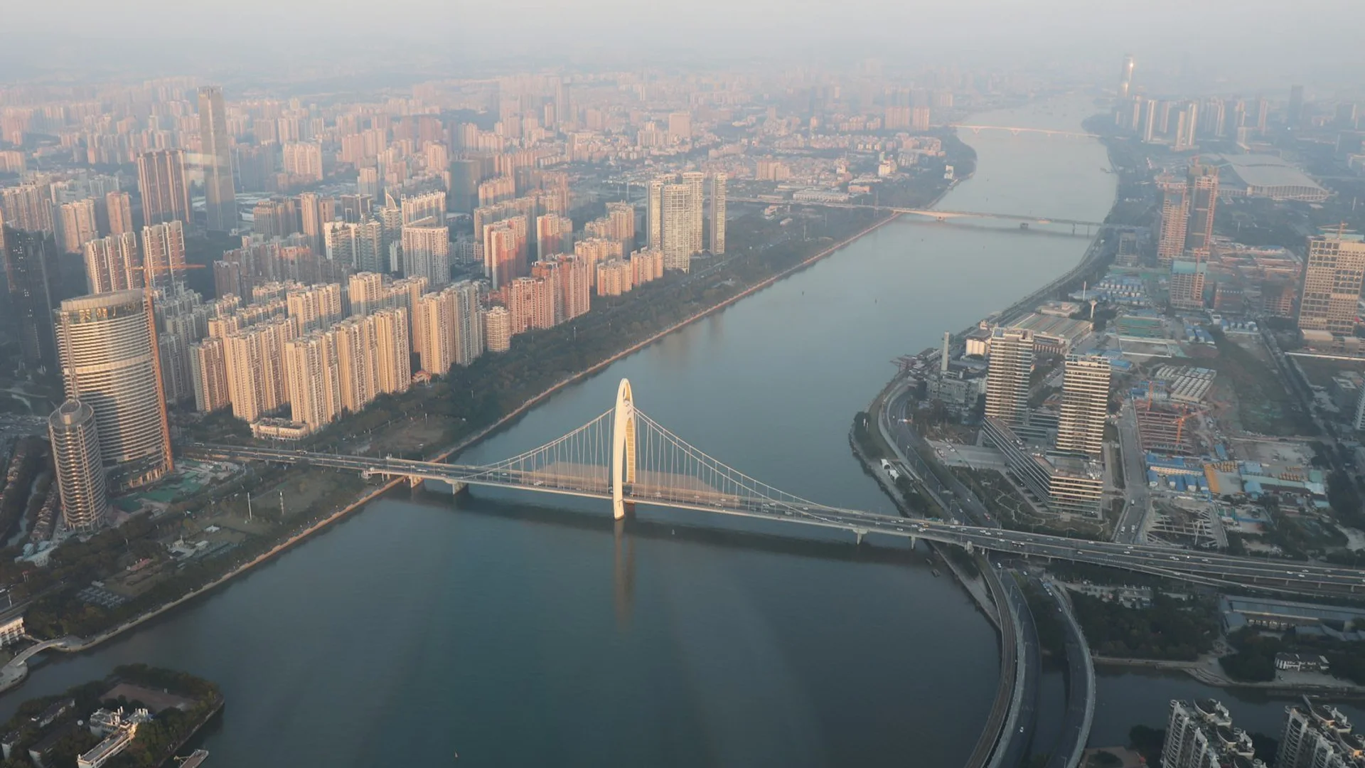 Vista aérea del skyline de Guangzhou al atardecer con la Torre Canton iluminada y el Río Perla