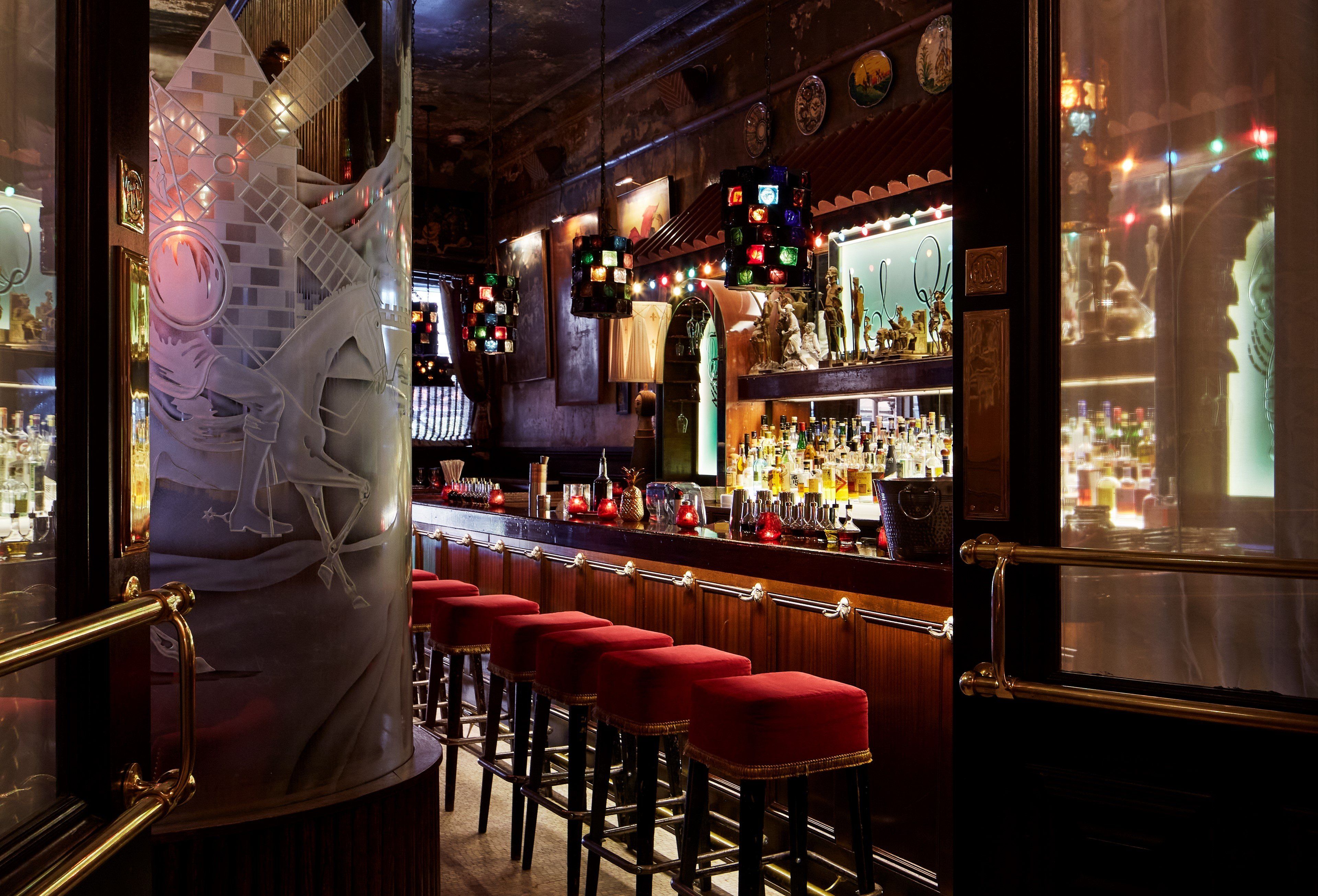 Escalera interior del Hotel Chelsea con pinturas de artistas residentes en las paredes, luz natural entrando por ventanas altas, ambiente bohemio preservado