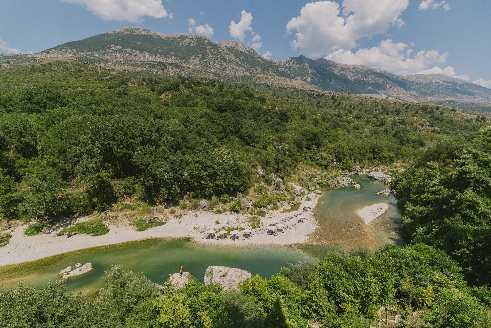 A lush river flows through a mountainous landscape.