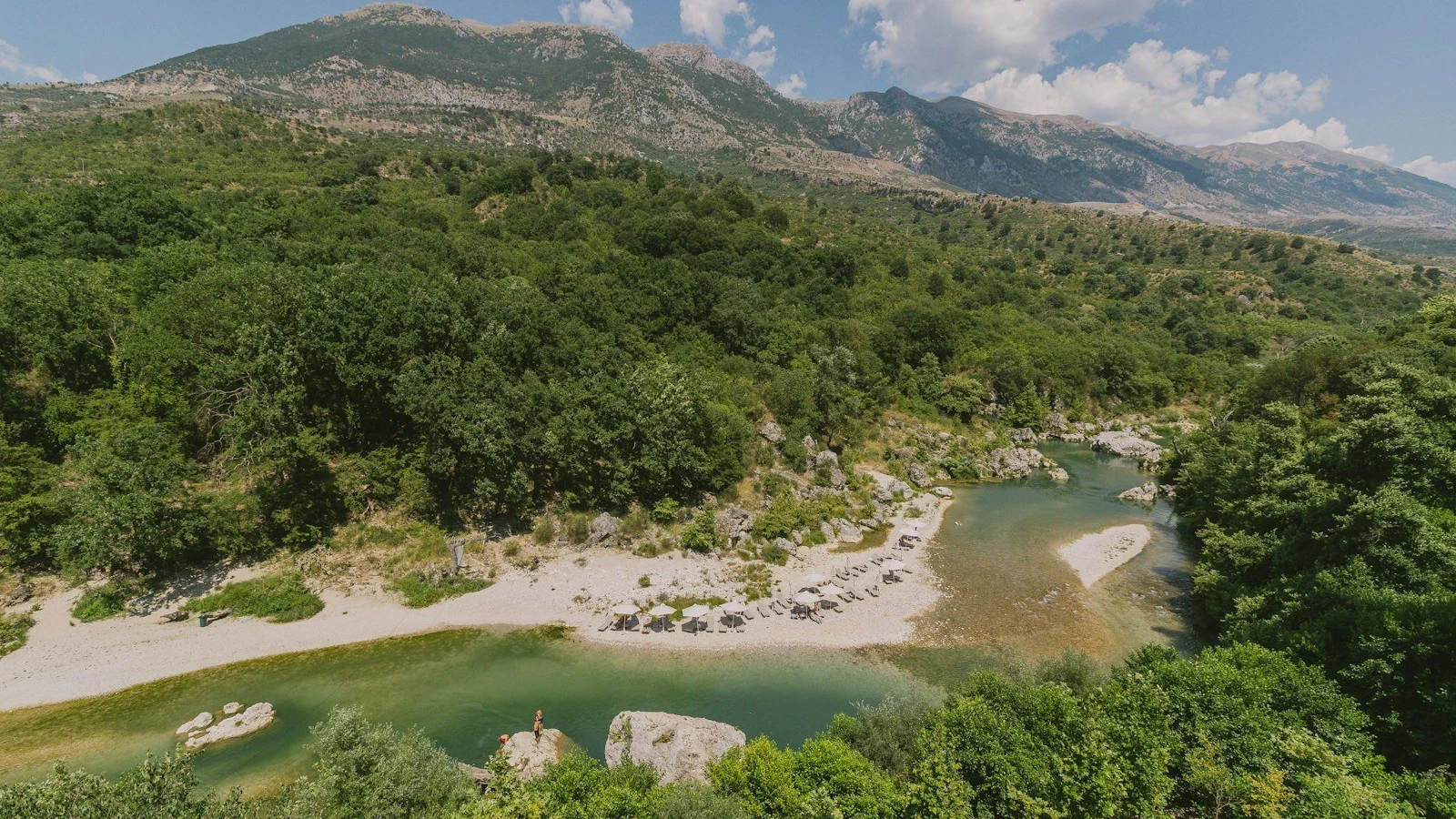 A lush river flows through a mountainous landscape.