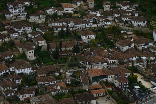 Vista aérea de un denso conjunto de casas blancas con tejados de terracota en una ladera.