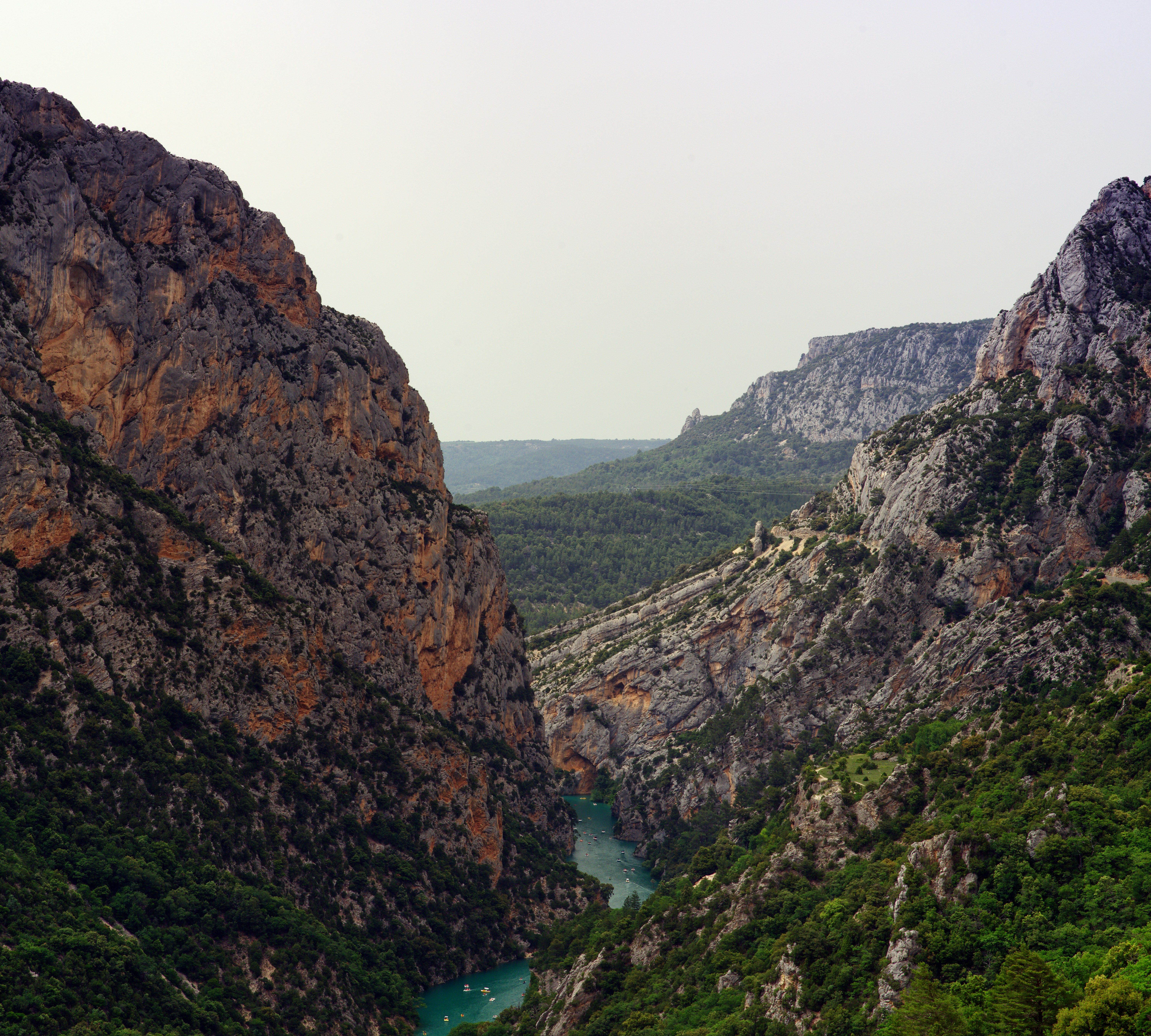 Vista aérea de un cañón rocoso con un río turquesa serpenteando entre las paredes.