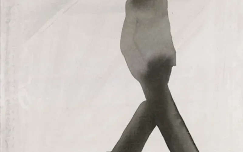 Silueta monocromática en acuarela de una figura femenina con sombrero ancho, caminando con elegancia sobre fondo blanco