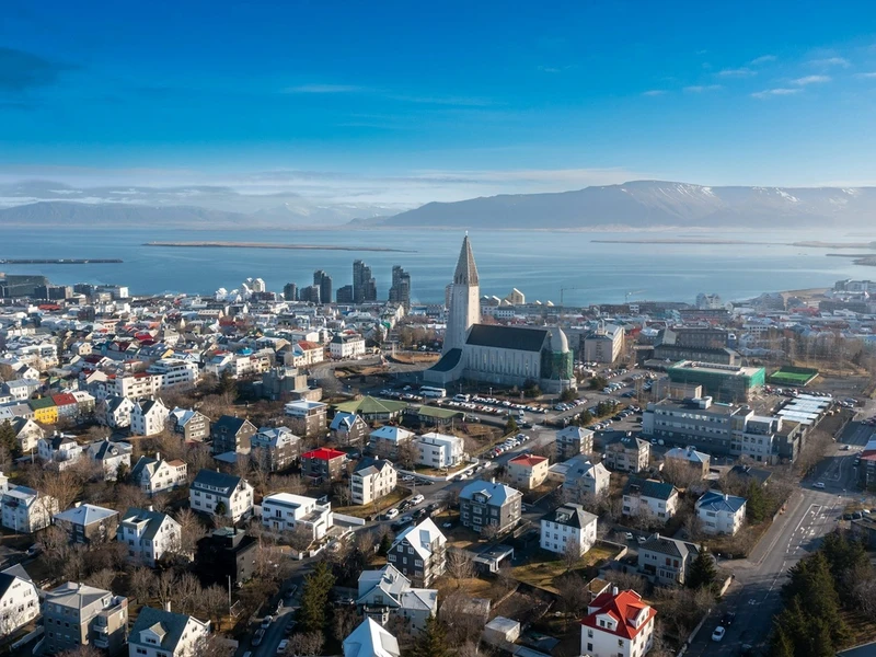 Vista aérea de la ciudad de Reykjavik con edificios coloridos, la iglesia blanca de aguja y el mar bajo un cielo azul claro