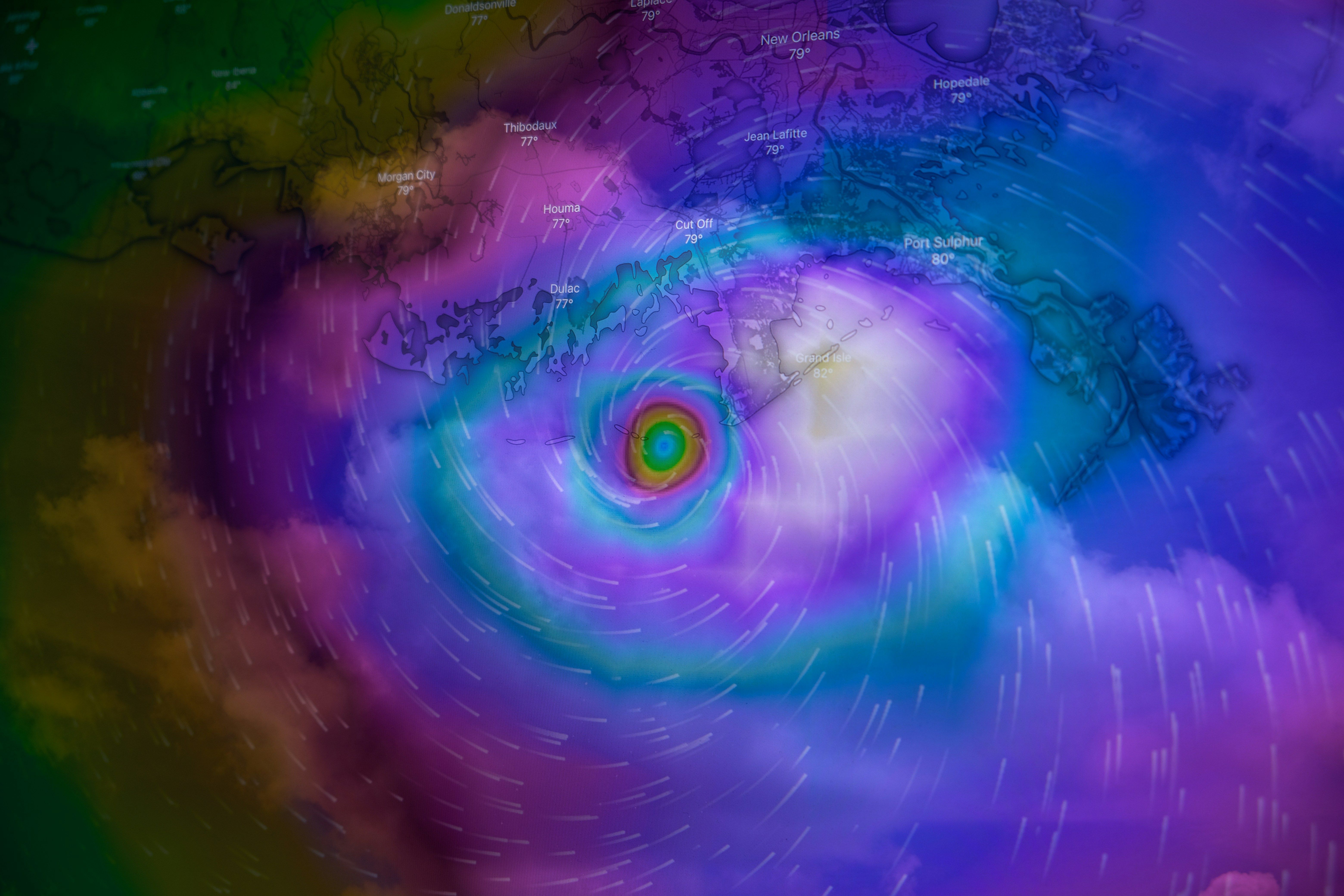 Mapa meteorológico digital con un huracán o ciclón de colores vibrantes sobre una masa de tierra.
