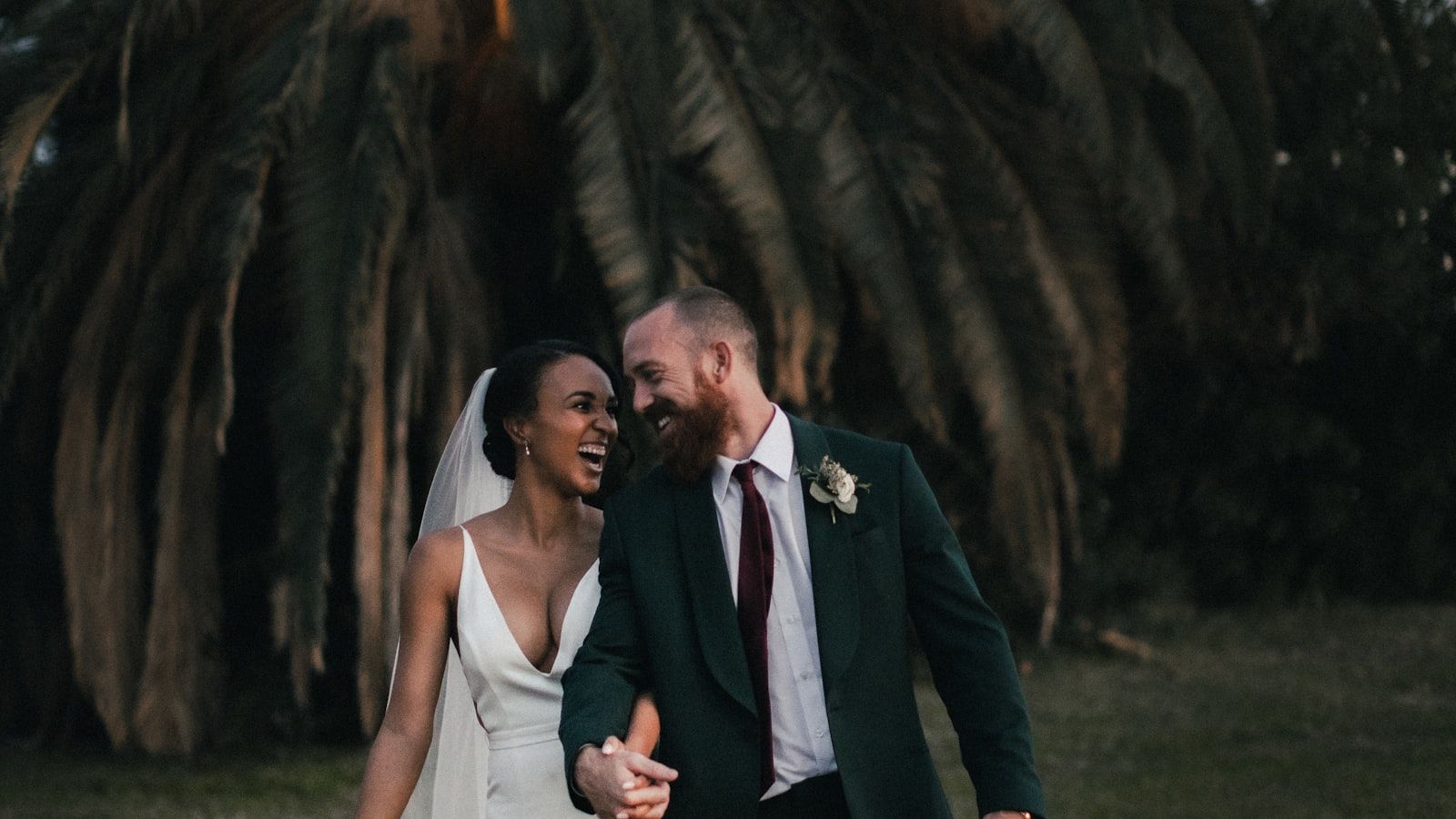 A wedding photographer backing up memory cards to a laptop and external SSD in the back of a car
