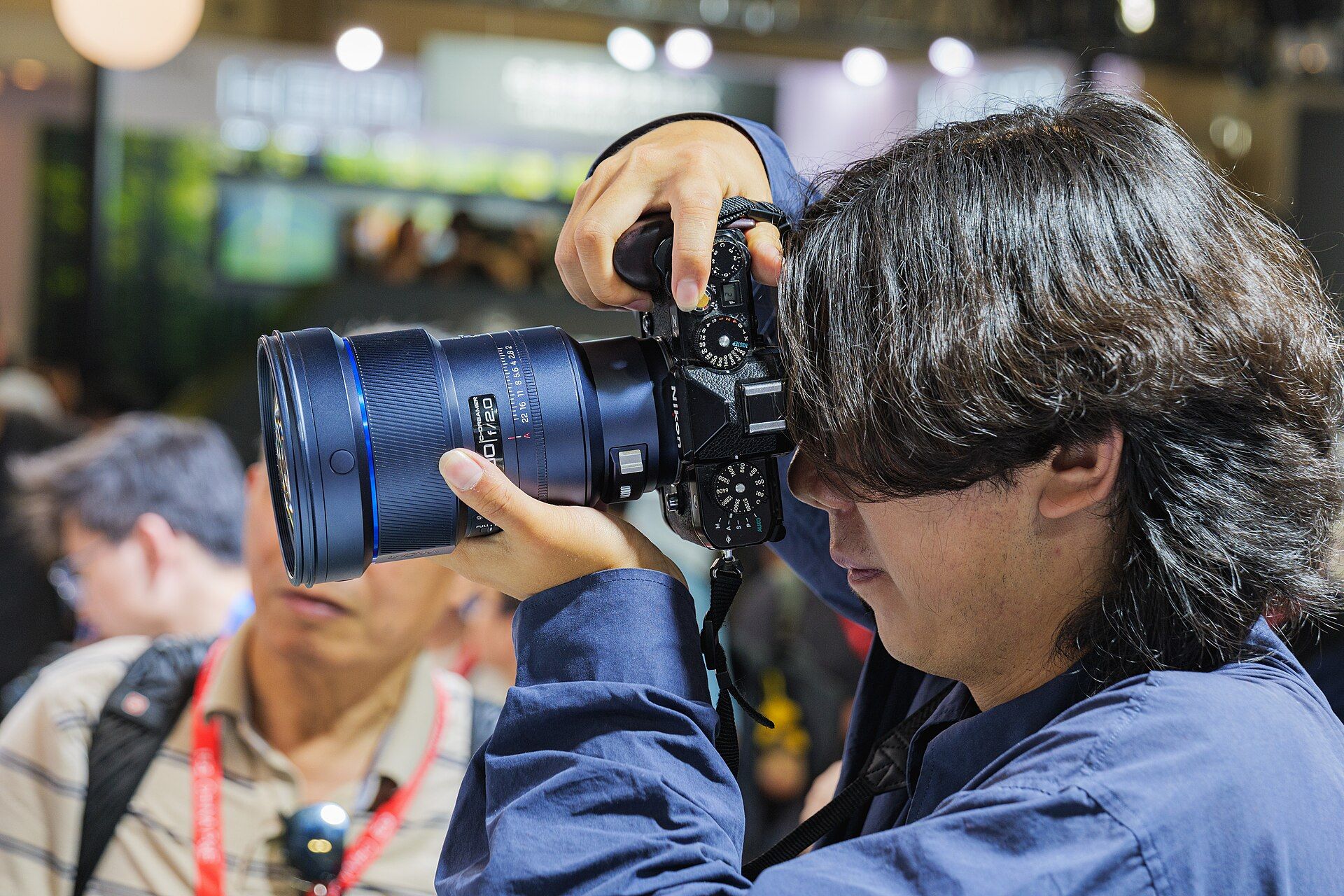 A photographer using a Nikon Zf with an adapted manual-focus lens