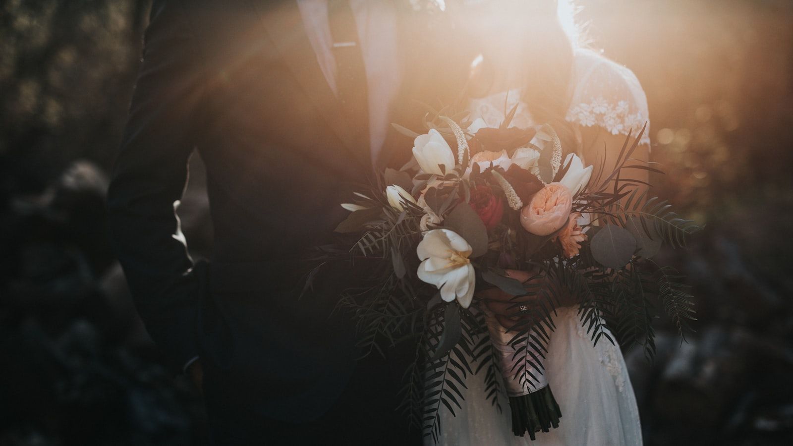 A wedding photographer reviewing backup workflow with memory cards and external SSD on a wooden table