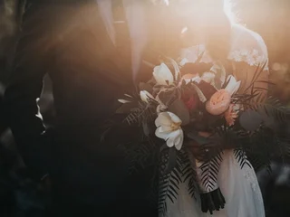 A wedding photographer reviewing backup workflow with memory cards and external SSD on a wooden table