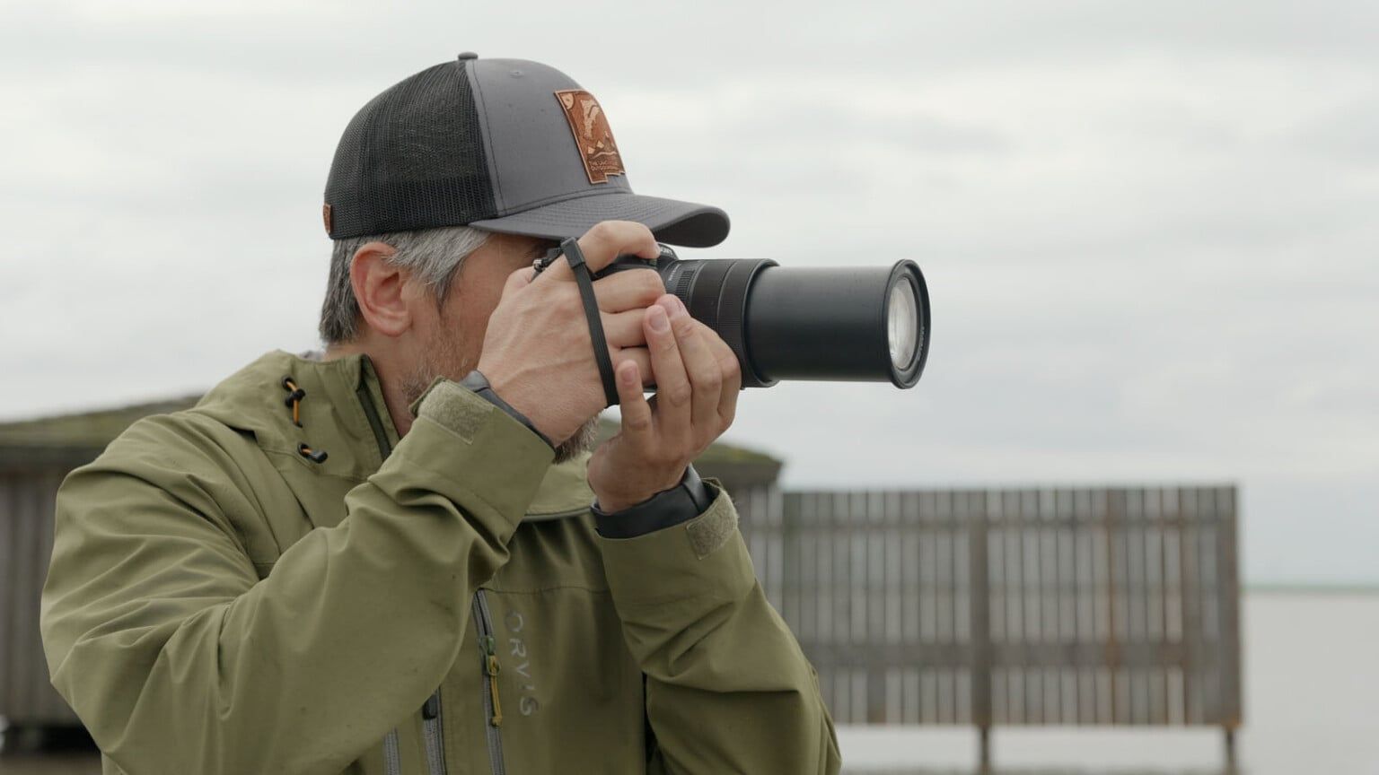 Sony RX10 V held in hand, showing the redesigned bridge-camera body and grip