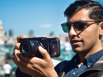 Caira mirrorless camera paired with a smartphone showing the AI editing interface