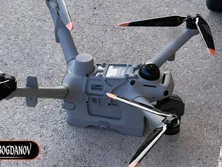 DJI Matrice 5TD prototype drone with arms folded on asphalt, showing top deck antenna and multi-window gimbal, photographed by Igor Bogdanov on September 26, 2026