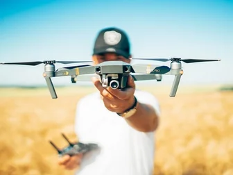 DJI Air 3S drone flying over a dramatic mountain valley