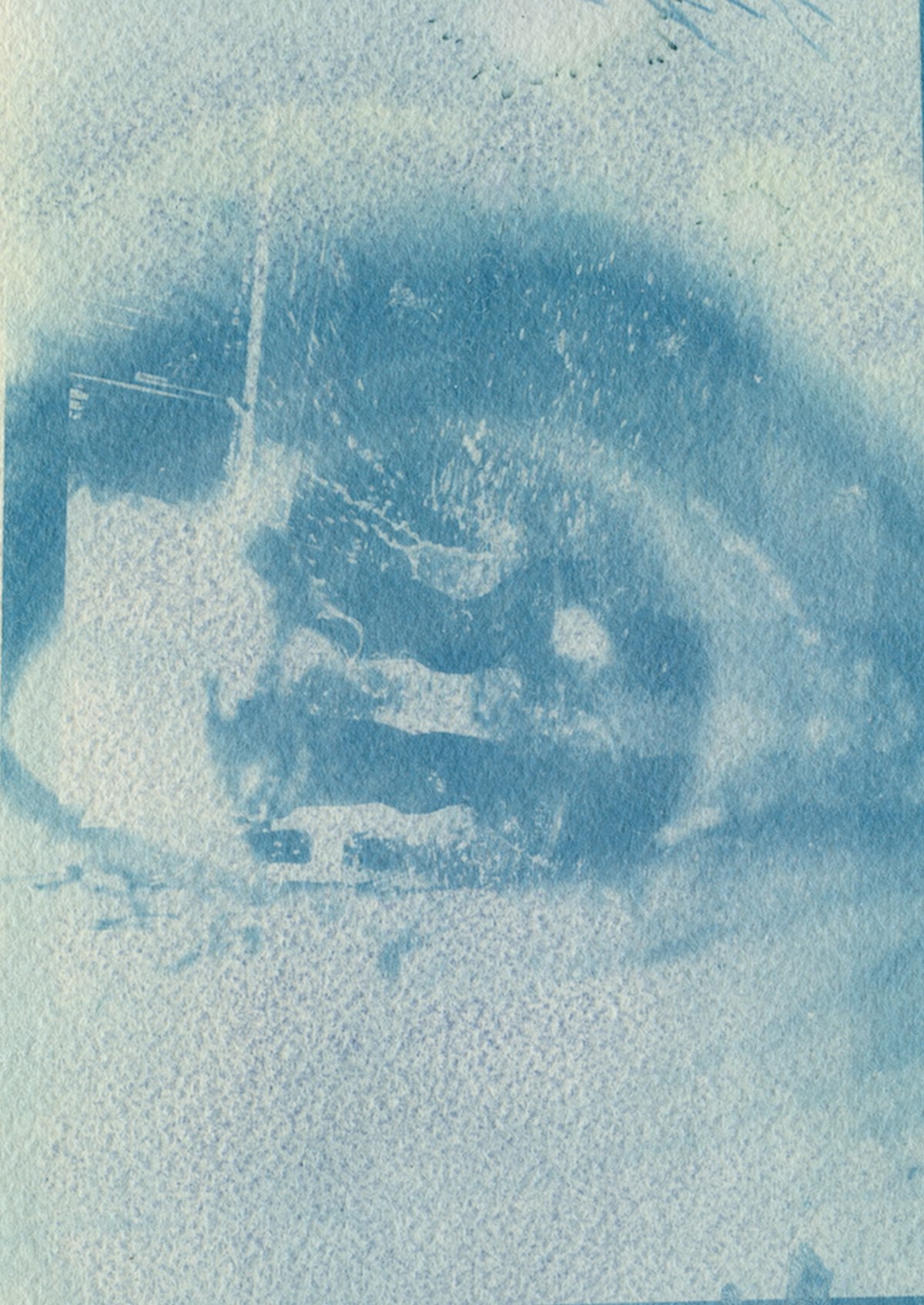 A pale, faded cyanotype of a large eye, its details washed out and blotchy.