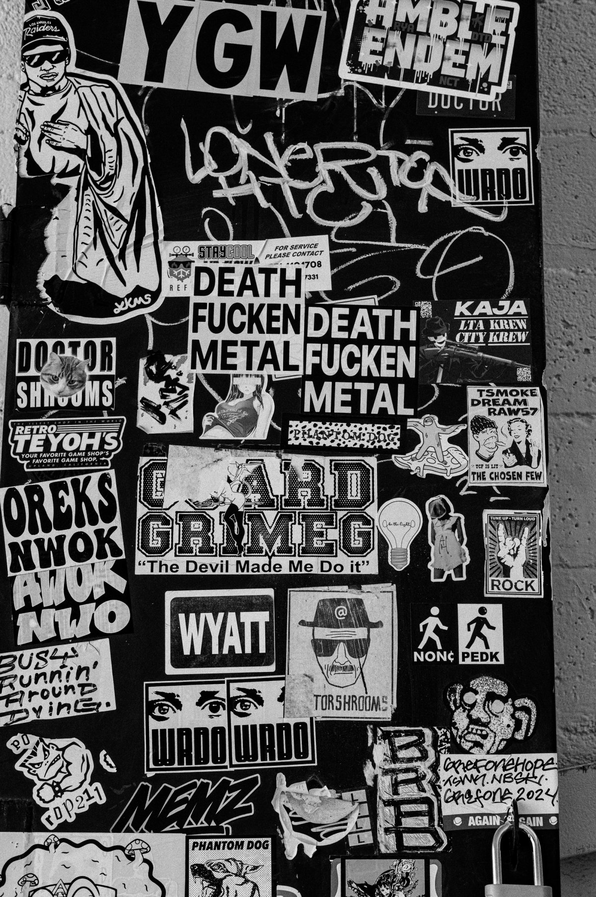 A utility box completely covered in band and street-art stickers.