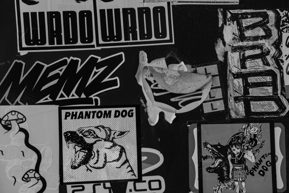 A tight crop of overlapping stickers: tags, a snarling dog and a cartoon girl.