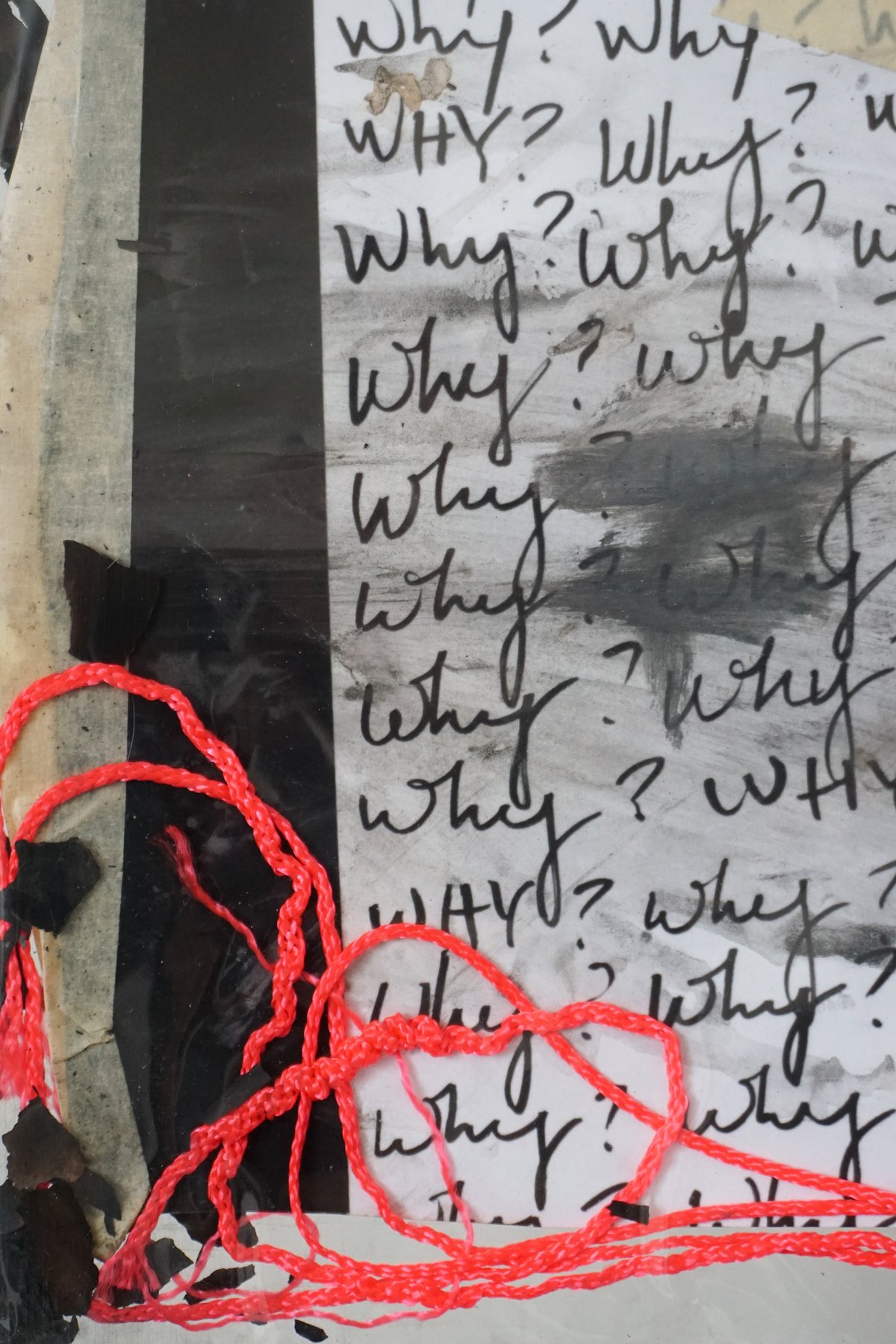 Detail of the collage: a column of handwritten 'Why?', smudged with soot, a red string coiled at the bottom.