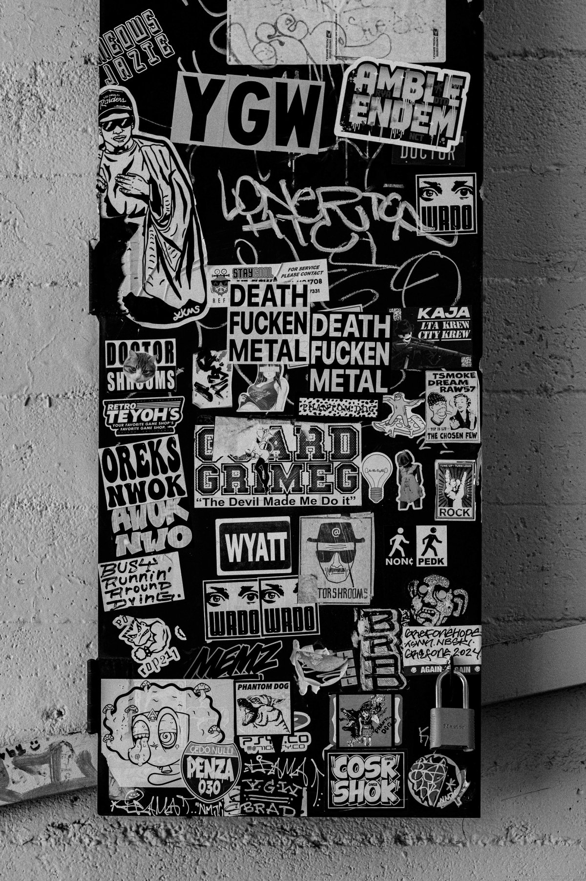 The whole sticker-covered utility box, standing against a textured wall.