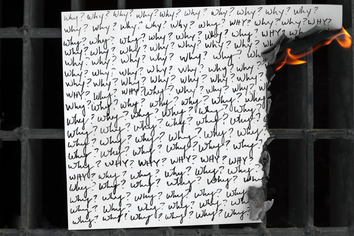 A sheet covered edge to edge in handwritten 'Why?' burning at its right edge, on a black metal grate.