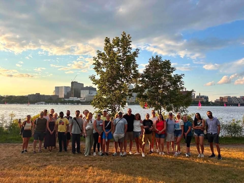 Group of people standing with the Charles River Esplanade in the background.