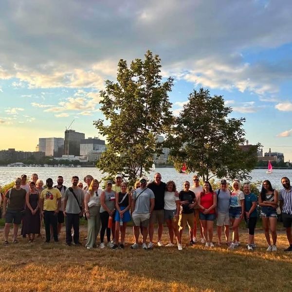 Group of people standing with the Charles River Esplanade in the background.