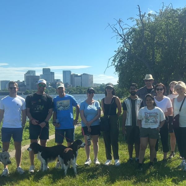 Group of people standing on the Esplanade with Boston in the background.