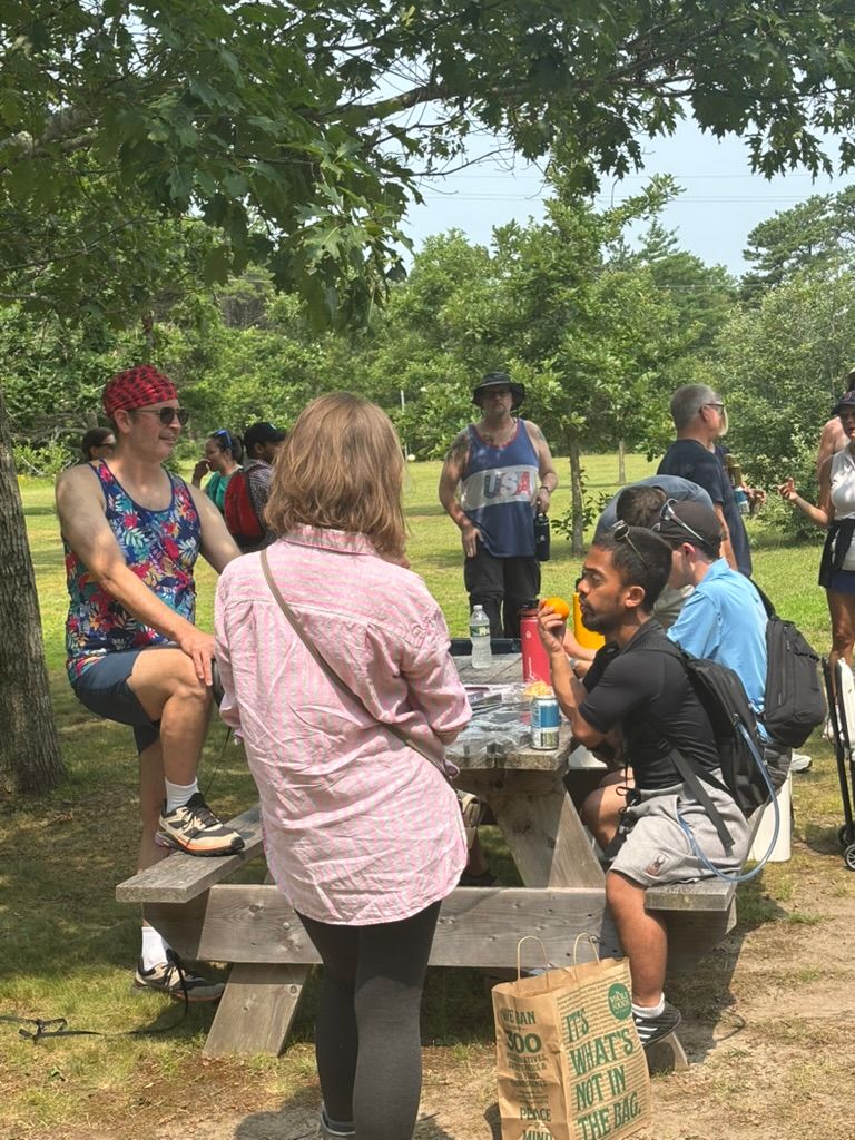 Members socializing at a picnic table after the Cape Cod hike