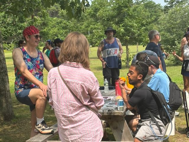 Members socializing at a picnic table after the Cape Cod hike