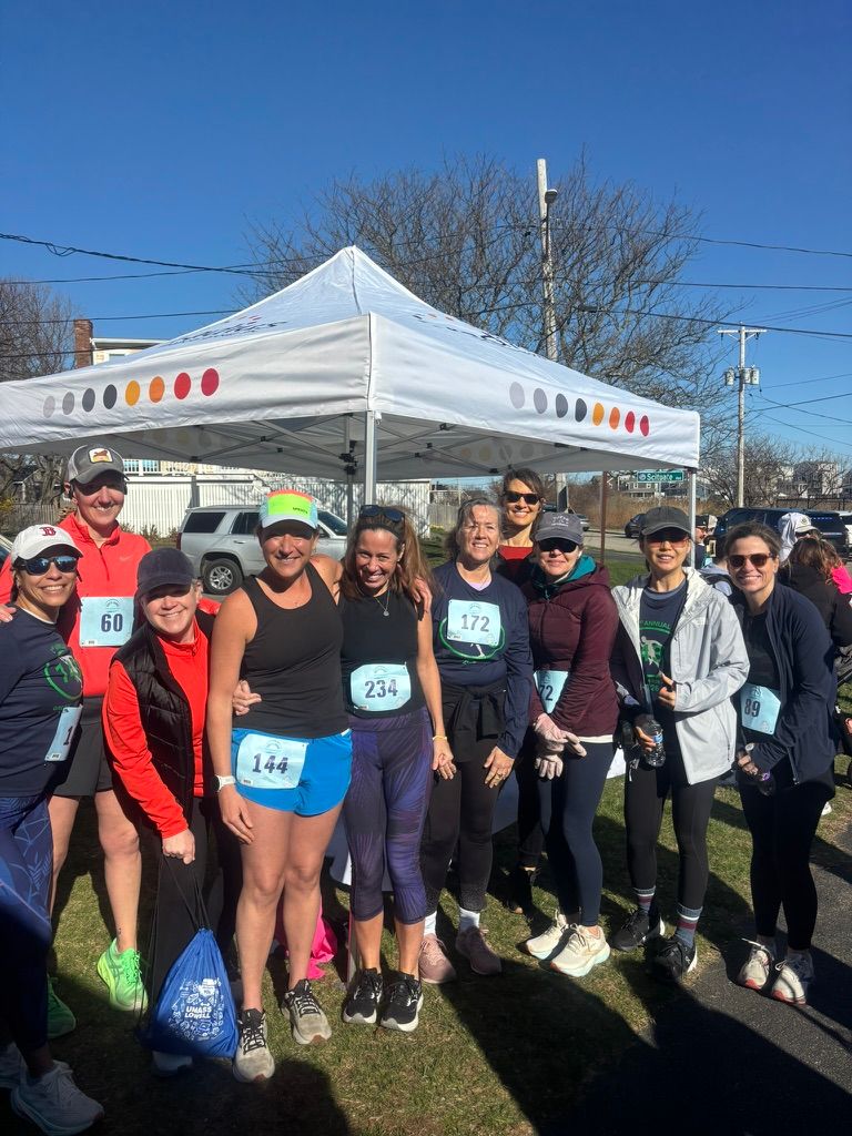 A group of people in front of a tent at a 5k.
