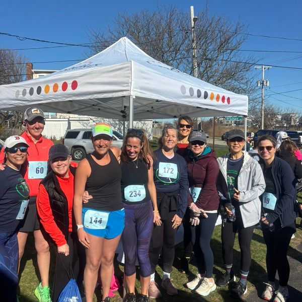 A group of people in front of a tent at a 5k.