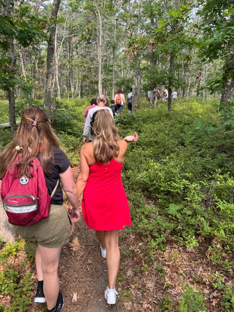 Woman pointing while hiking with a larger group of people.