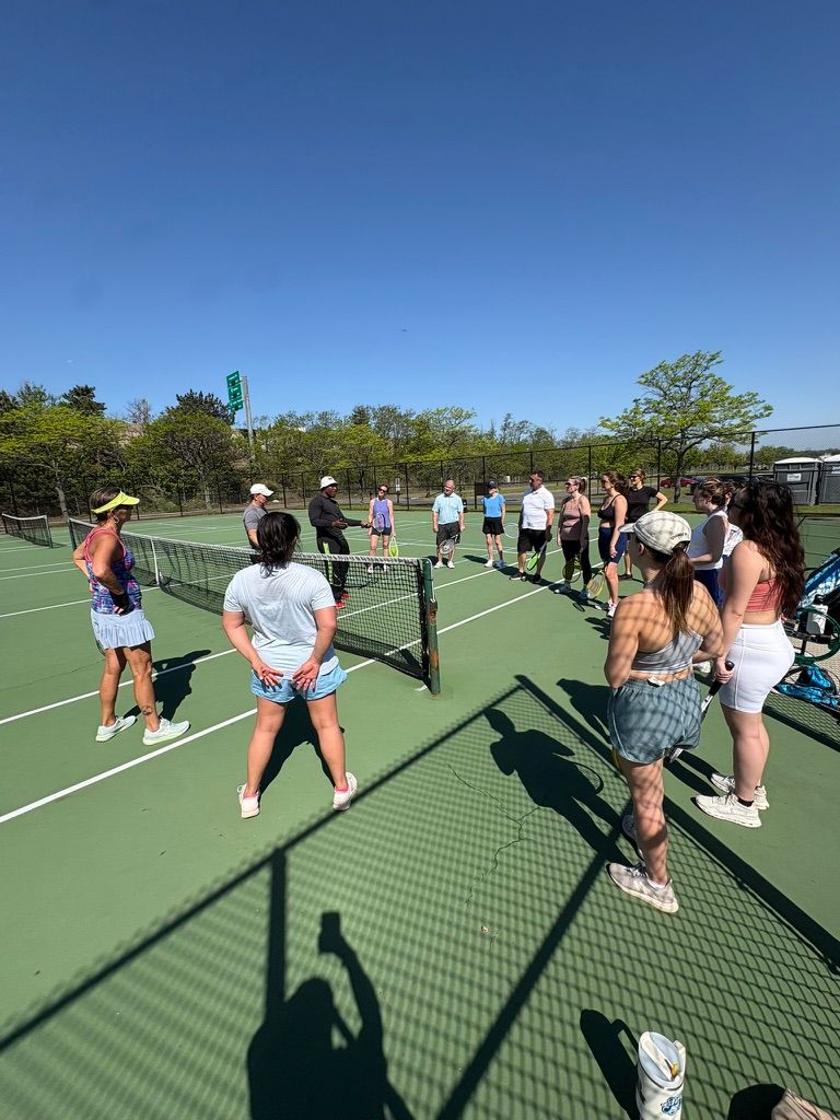 Circle of people around a tennis net.