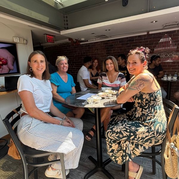 Four women seated at a table at a coffee tasting.