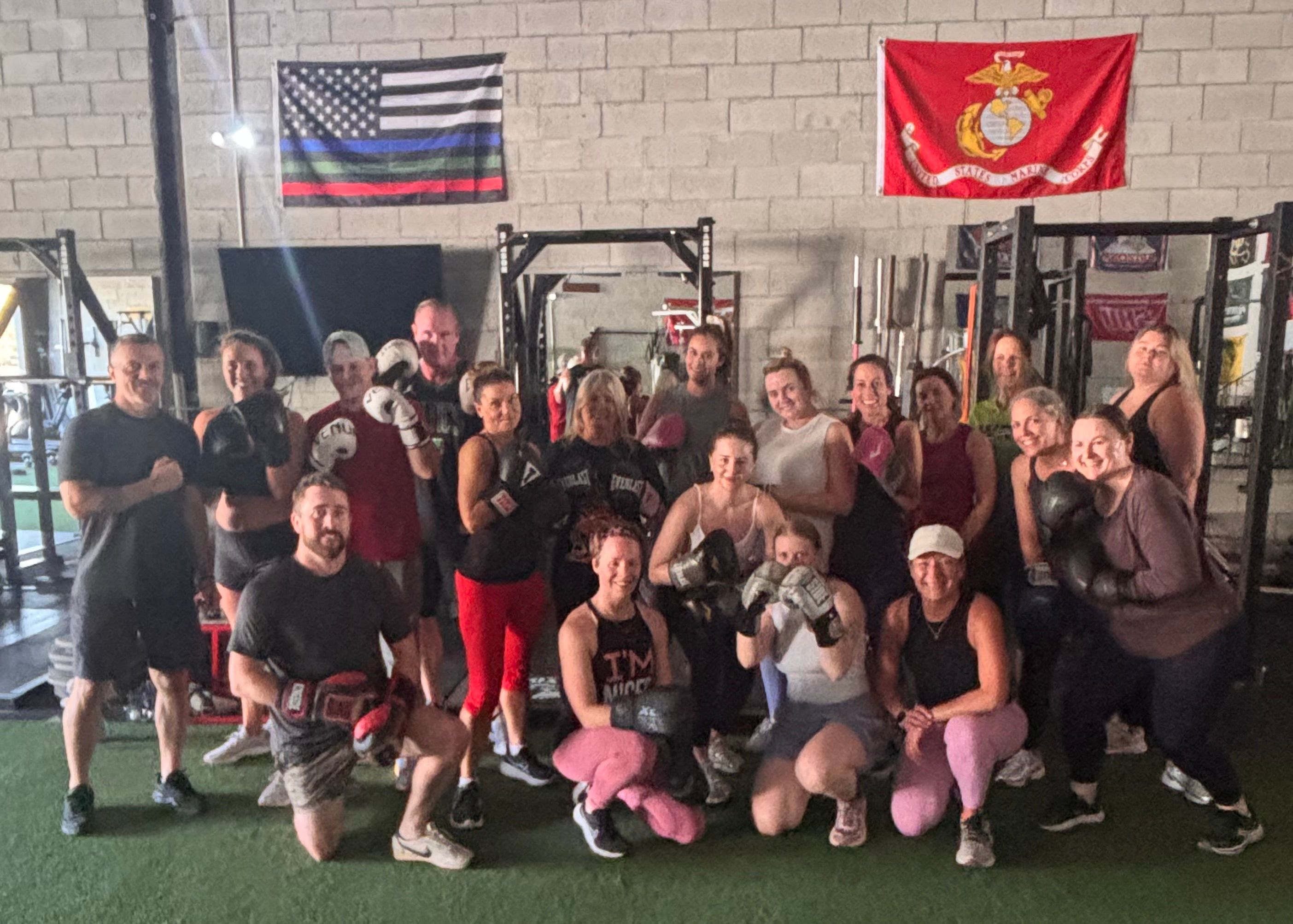 Group of people at boxing class standing and kneeling.