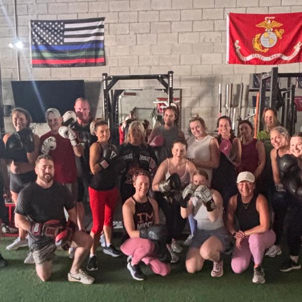 Group of people at boxing class standing and kneeling.