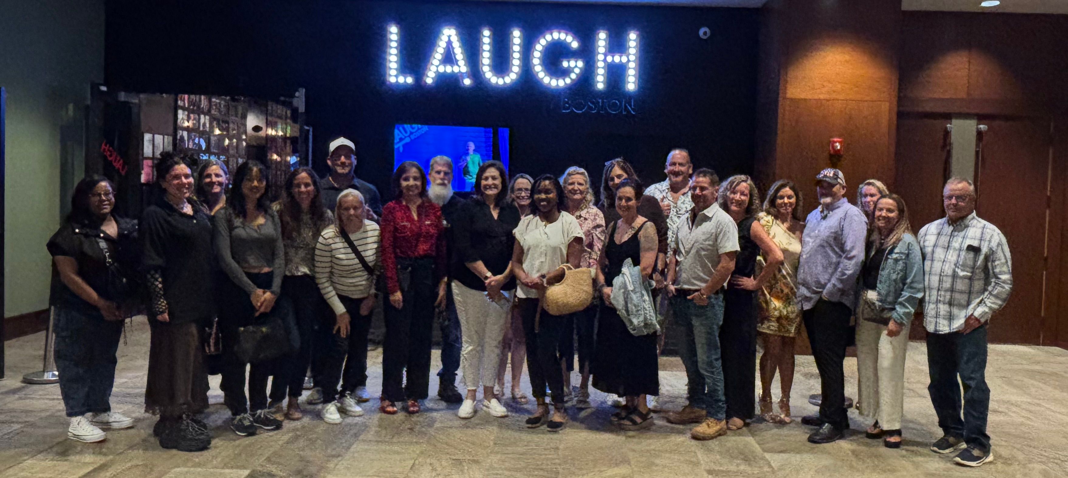 Group of people in front of Laugh Boston sign.