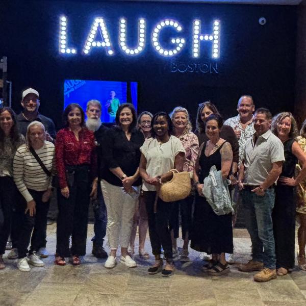 Group of people in front of Laugh Boston sign.