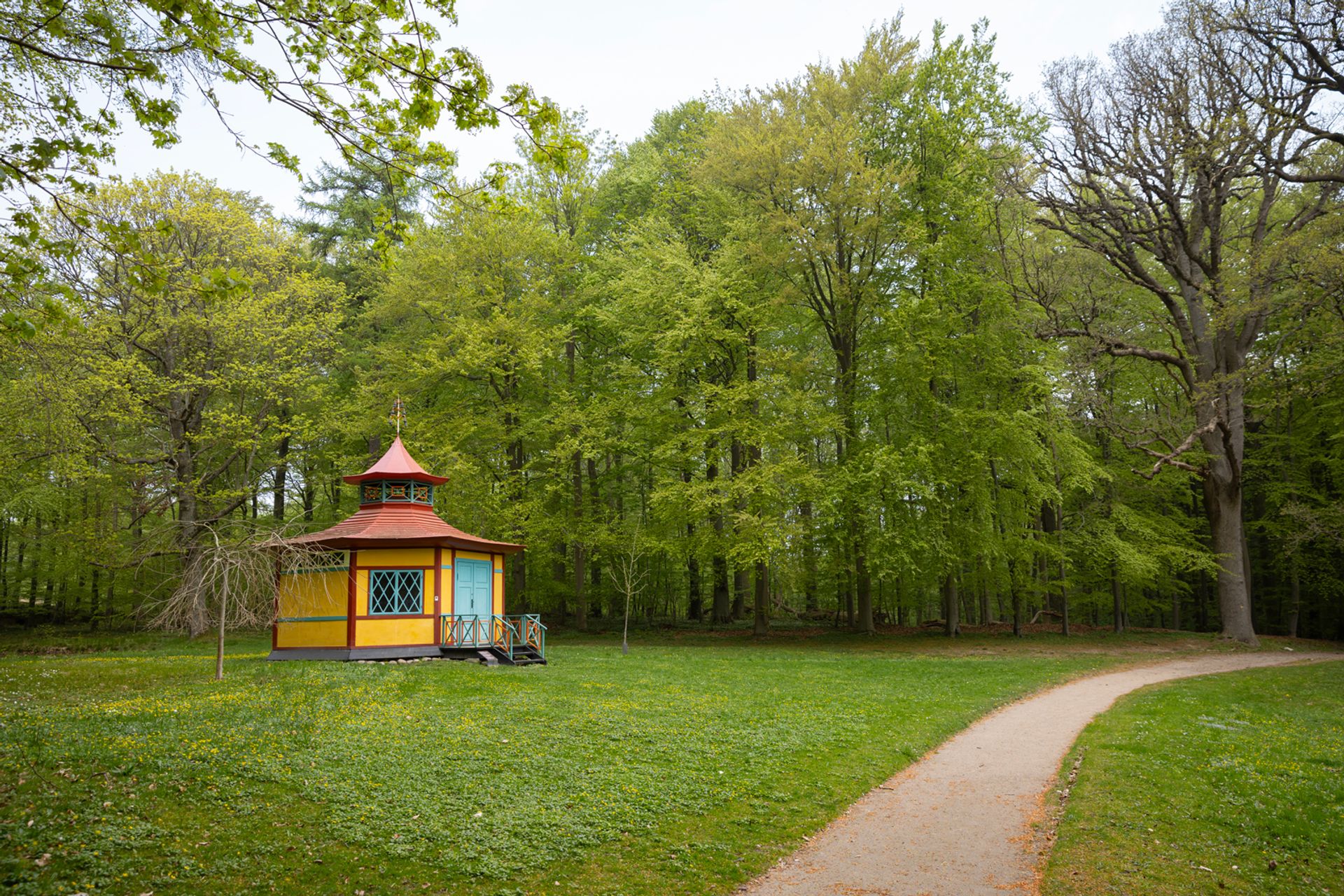 Det Kinesiske Lysthus ligger som et farverigt blikfang for enden af stien gennem Liselund Park.