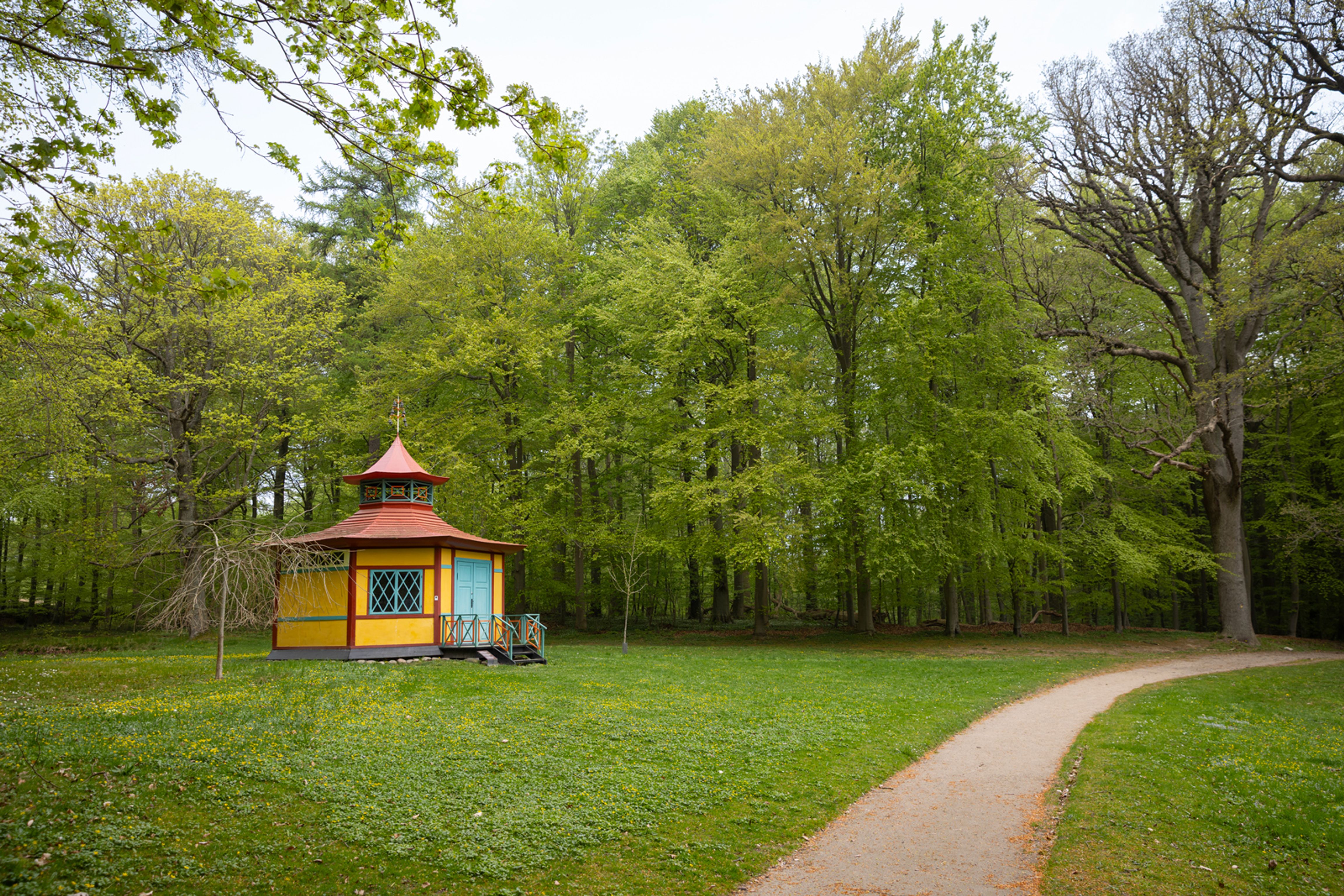 Det Kinesiske Lysthus ligger som et farverigt blikfang for enden af stien gennem Liselund Park.