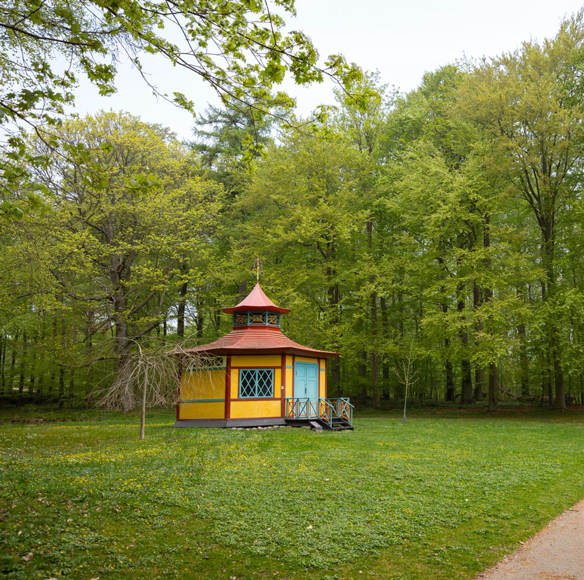 Det Kinesiske Lysthus ligger som et farverigt blikfang for enden af stien gennem Liselund Park.