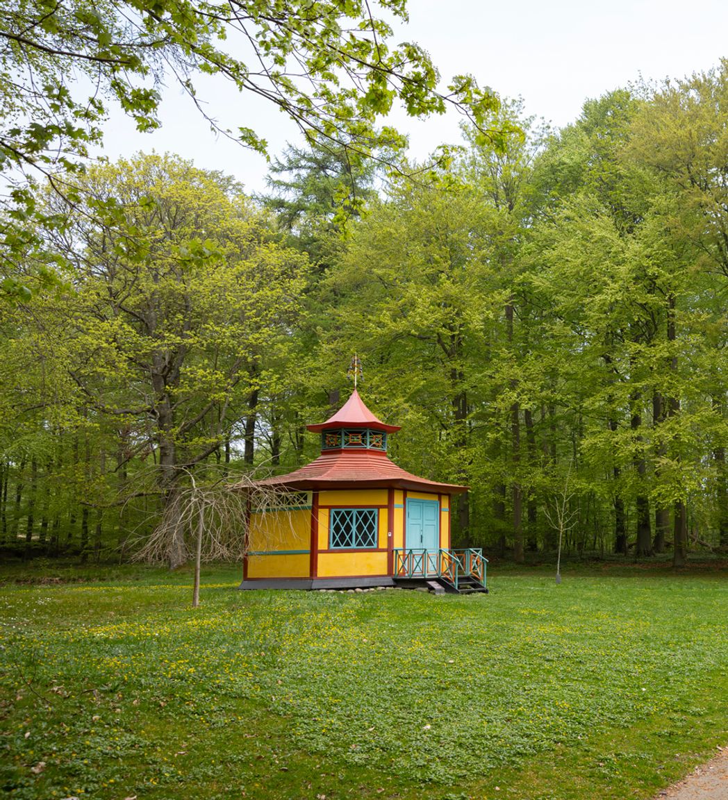 Det Kinesiske Lysthus ligger som et farverigt blikfang for enden af stien gennem Liselund Park.