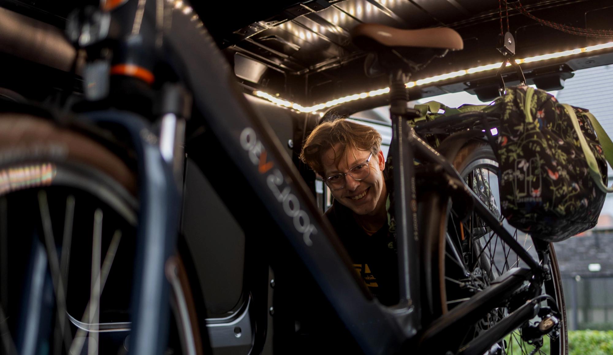 Bicycle mechanic repairing bicycle in a van