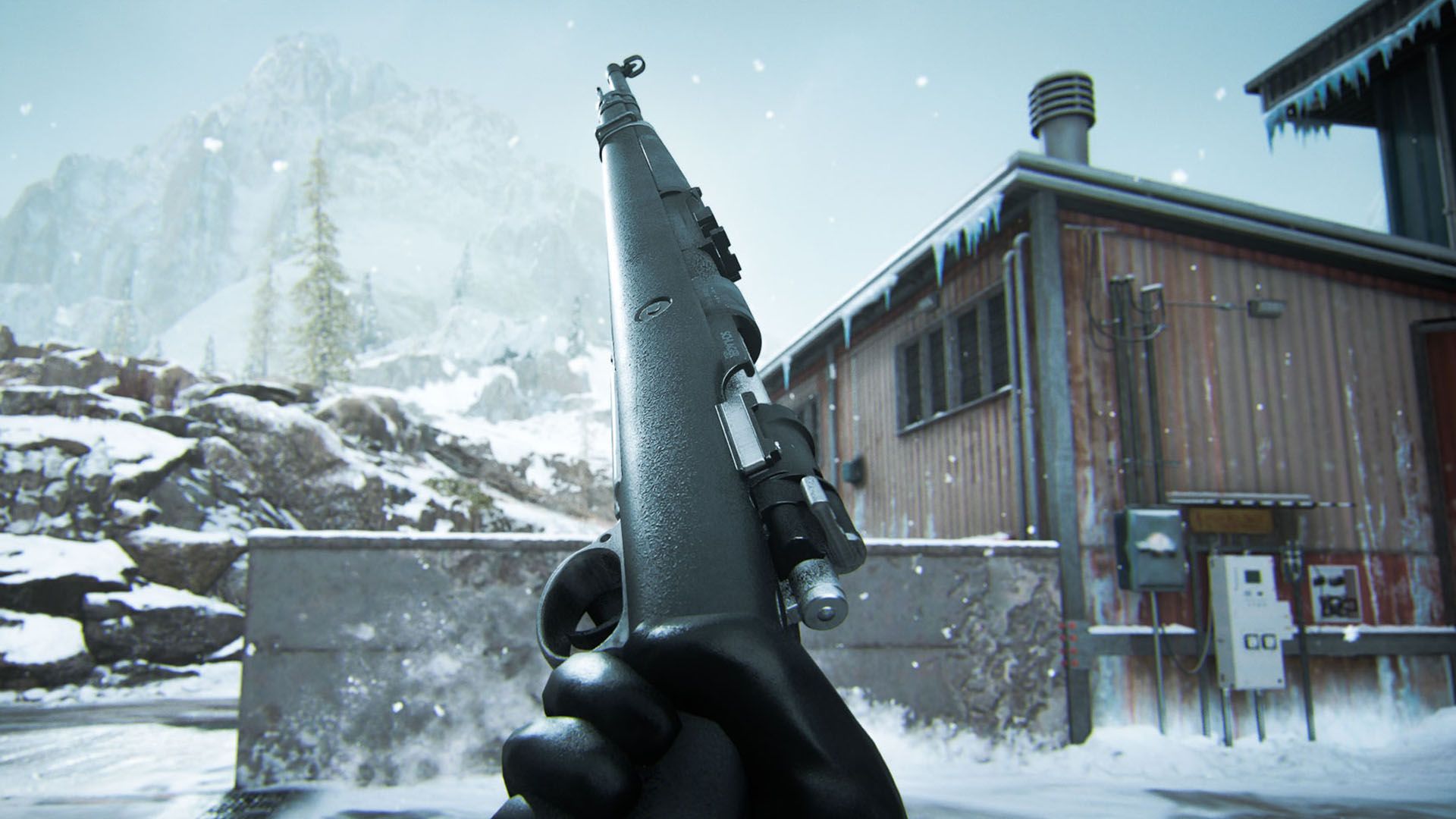Warzone player holding Kar98k marksman rifle with snow-covered building and rocks in background