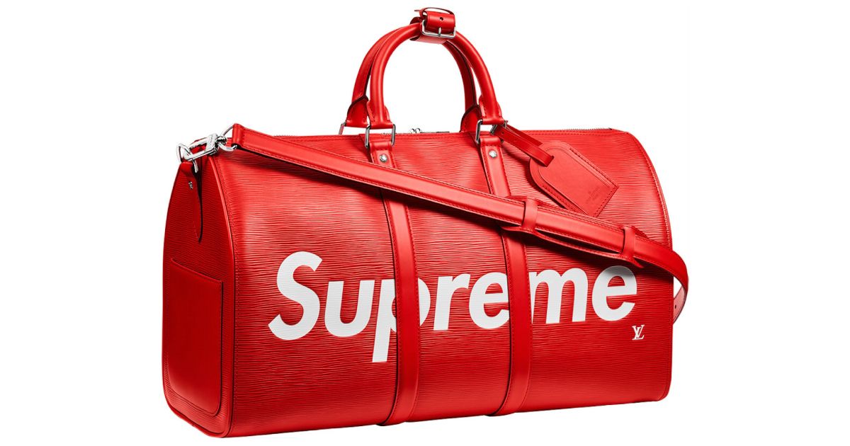 A red duffel bag with the Supreme and LV logo in white on it.