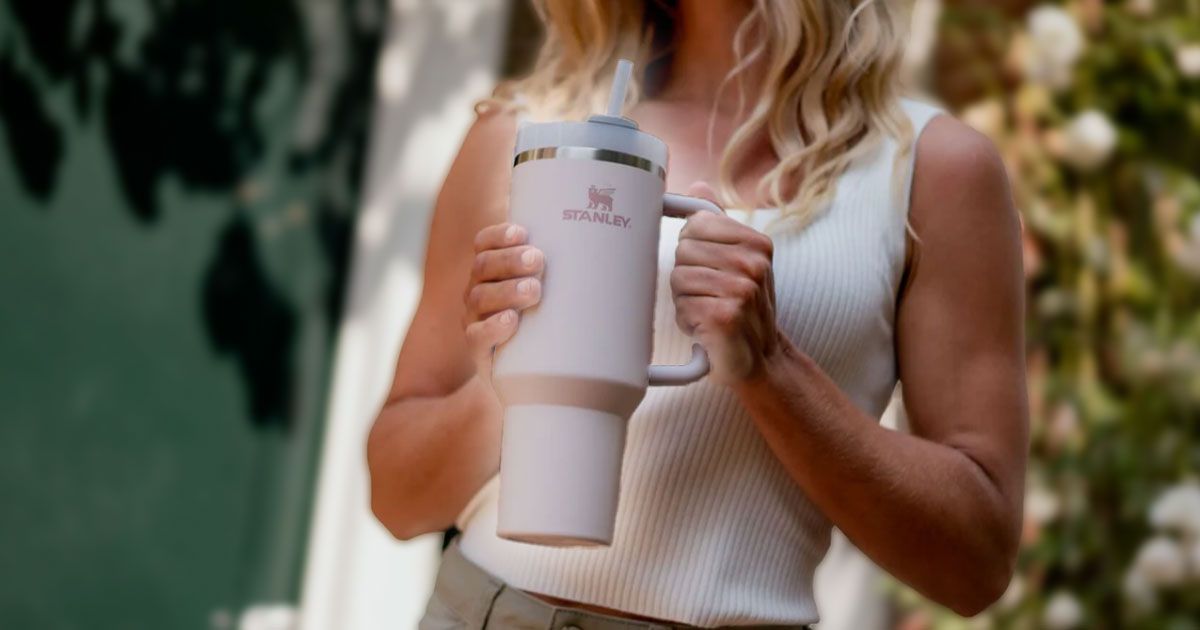 Person in a white top holding a Stanley Quencher cup.