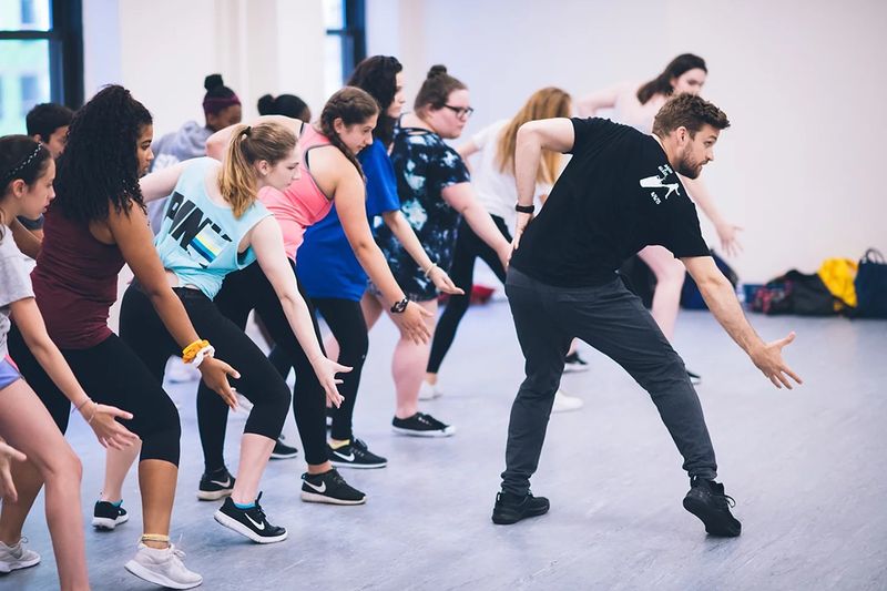 A group workshop rehearsing choreography together in a dance studio