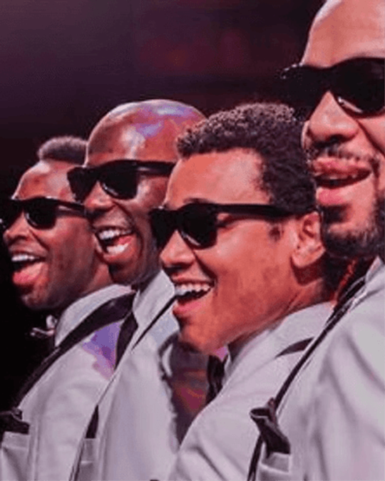 Correy West performing on stage with fellow cast members