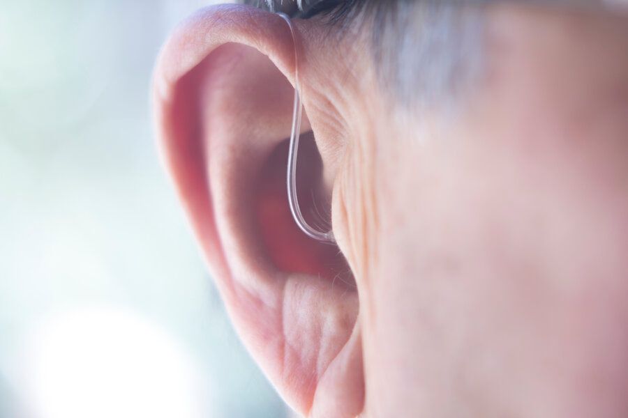 Closeup of hearing aid and top tips to adjust to hearing aids