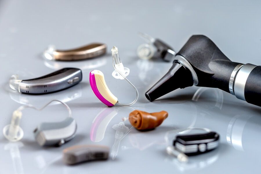 An assortment of hearing aids on an exam table